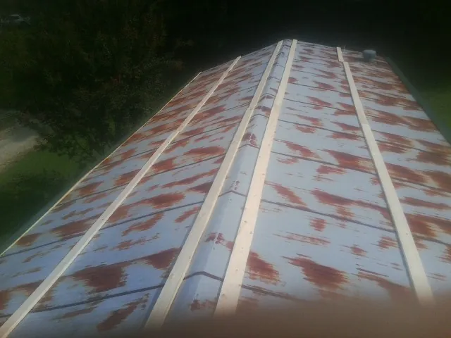 Rusted metal roof panels with new wood purlins before replacement — Storm Damage Roof Repair in Brave by Roofing Brothers