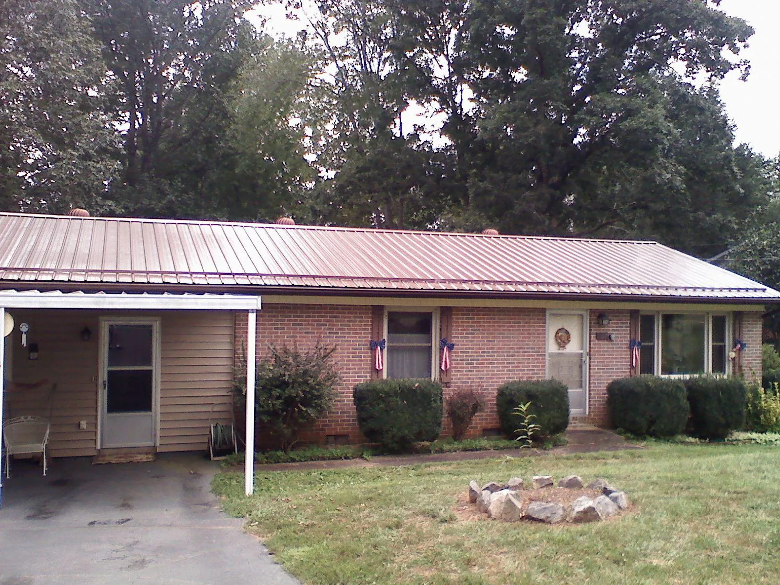 Bronze metal roof and carport on a brick ranch home — Roof Repair work by our crew in Brave