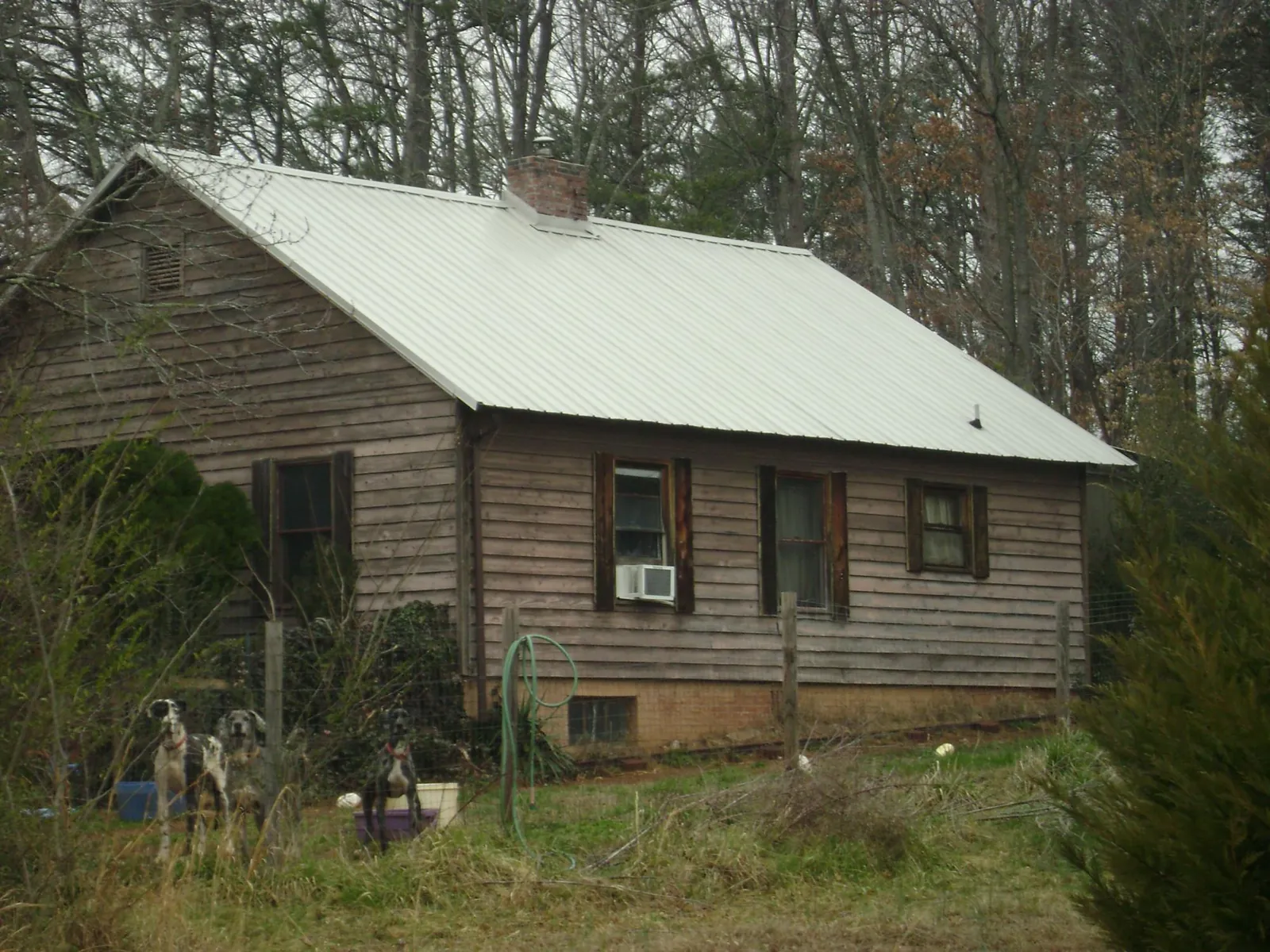 White metal roof on an old wood sided farmhouse, from a Metal Roof Installation job in Brave
